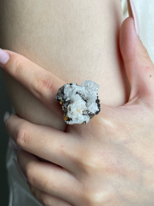 Close up of raw Creedite crystal cluster ring worn on hand