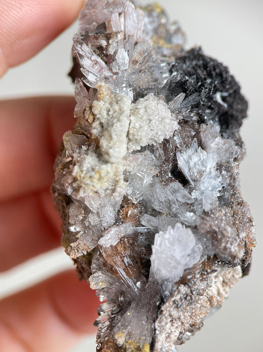 Close-up of pale Creedite flower crystal clusters on natural matrix