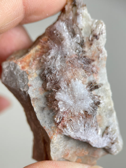 Close-up of radiating Creedite flower crystals on natural matrix