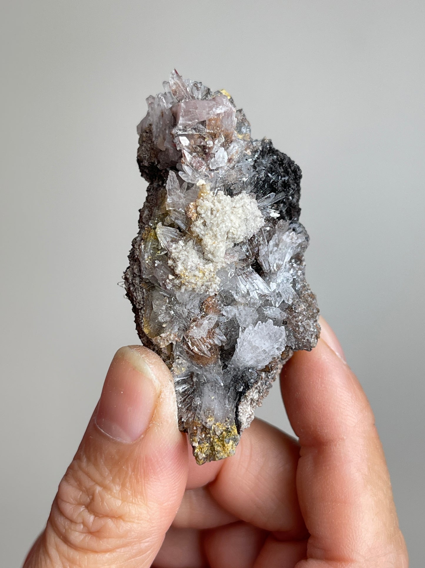 Handheld Raw Creedite flower mineral specimen showing natural size and texture