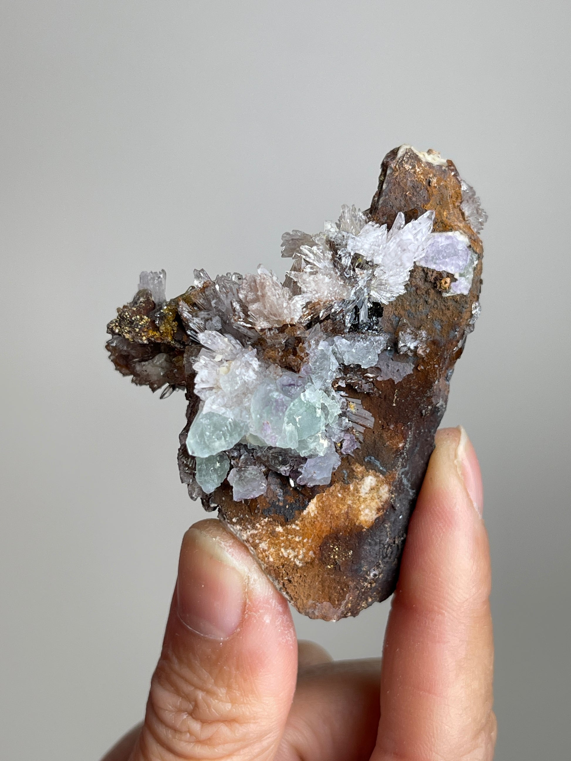 Handheld Raw Creedite flower mineral specimen showing natural size and texture