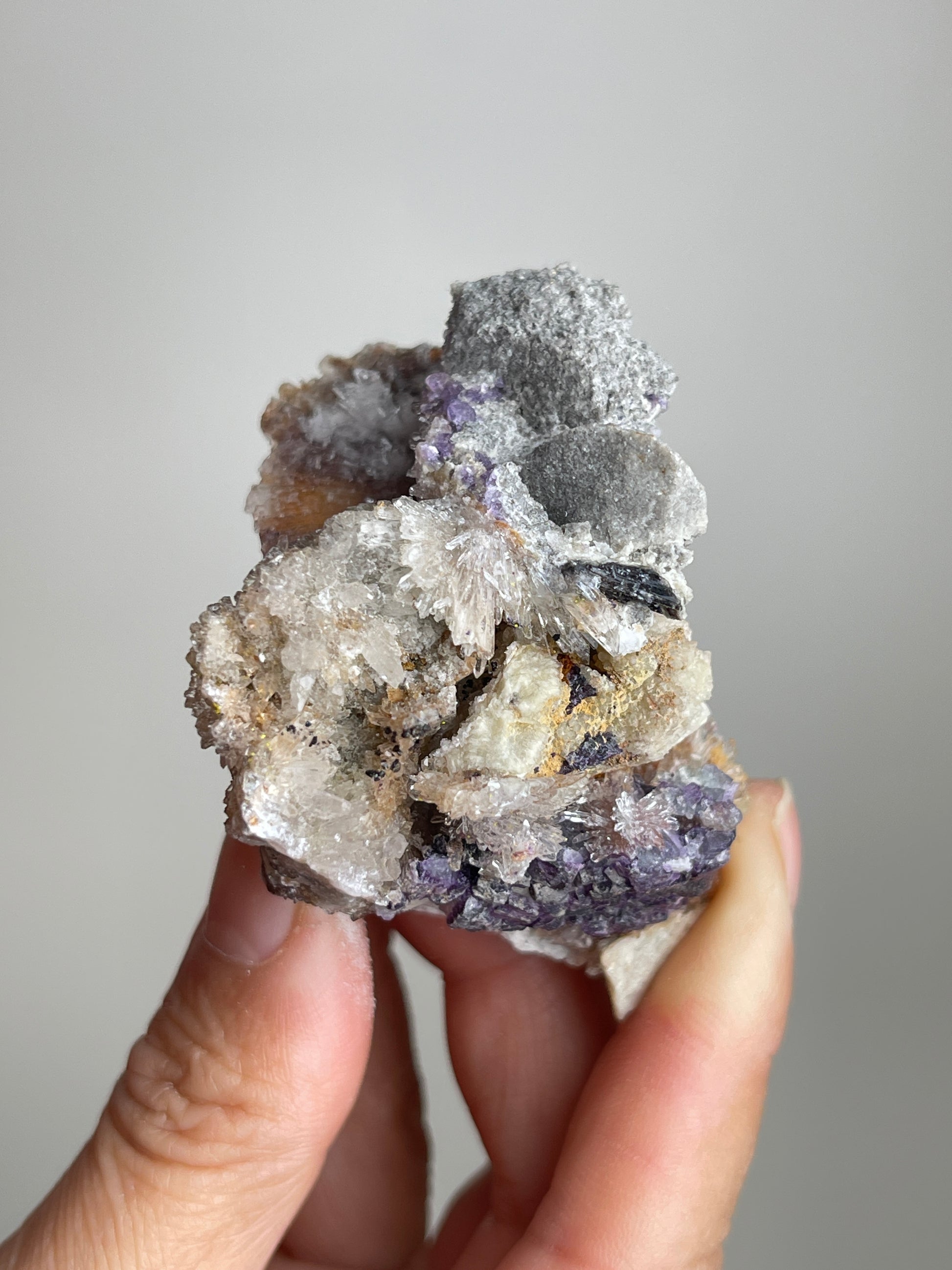 Handheld Raw Creedite flower mineral specimen showing natural size and texture