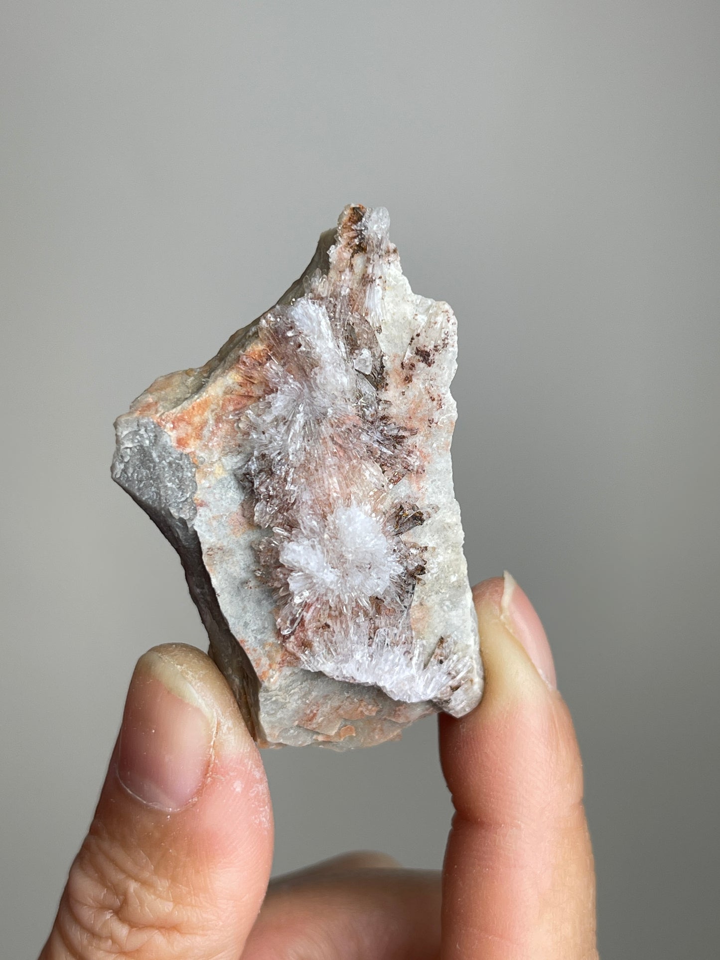 Handheld Raw Creedite flower mineral specimen showing natural size and crystal detail