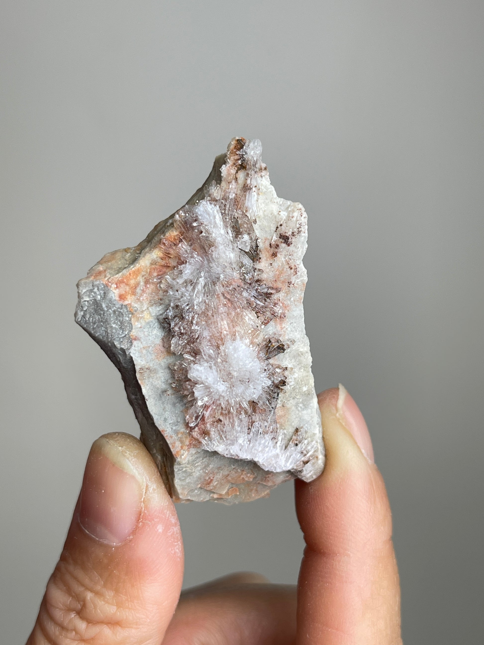 Handheld Raw Creedite flower mineral specimen showing natural size and crystal detail