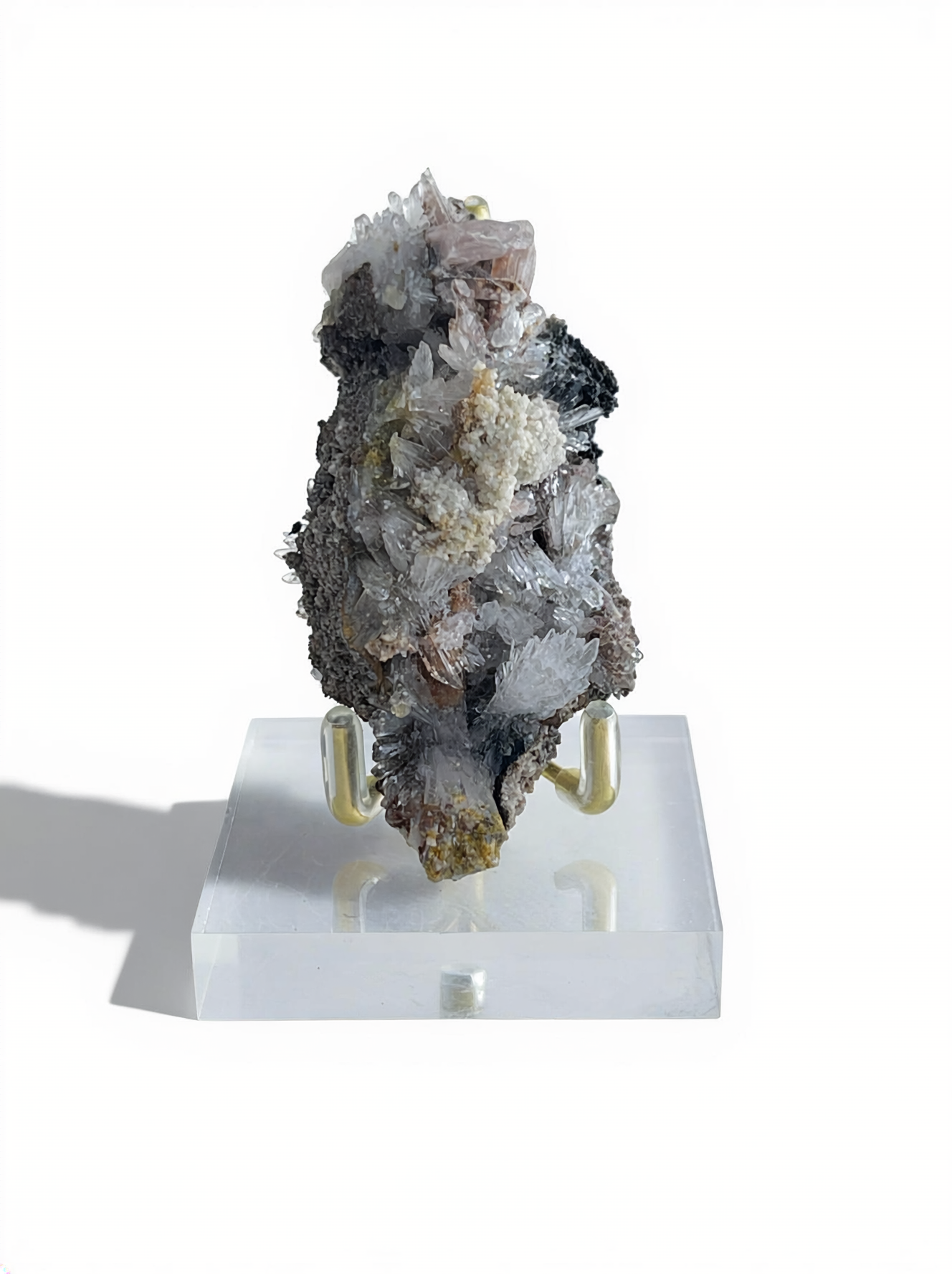 Raw Creedite flower mineral specimen on matrix with display stand