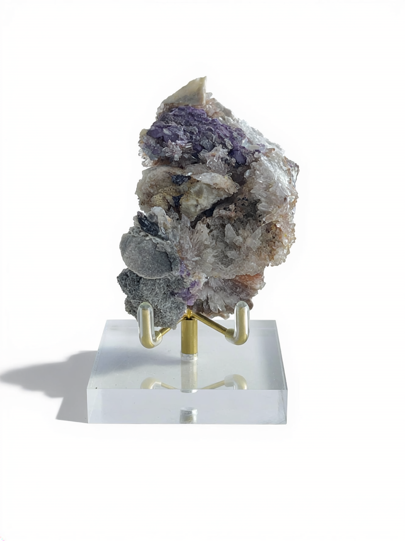 Raw Creedite flower mineral specimen on mixed matrix with display stand