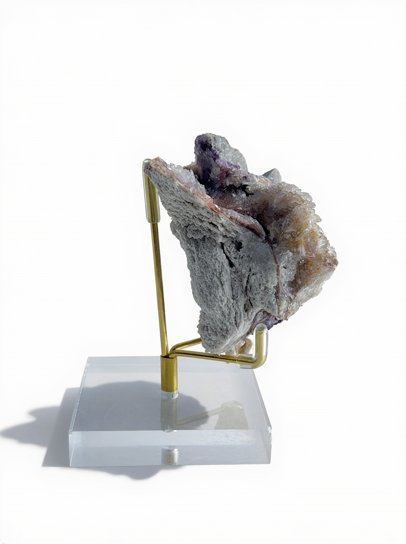 Side view of Raw Creedite flower mineral specimen on display stand