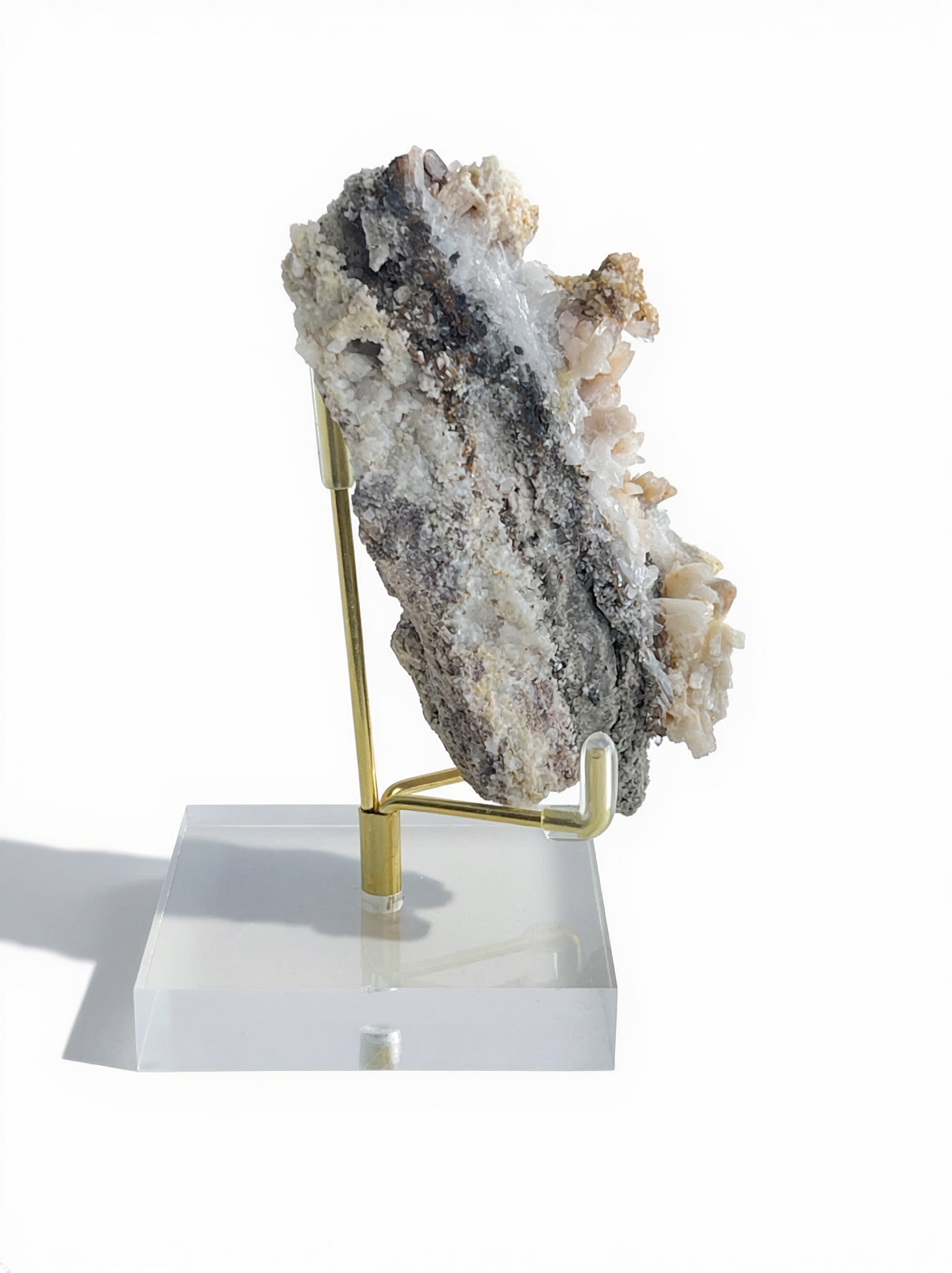 Side view of tall Raw Creedite mineral specimen on display stand