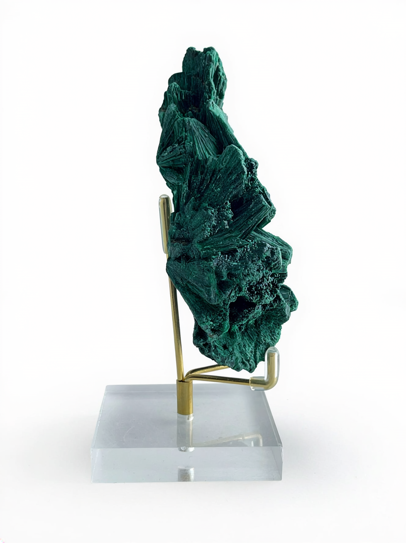 Raw fibrous malachite mineral specimen on display stand, side view