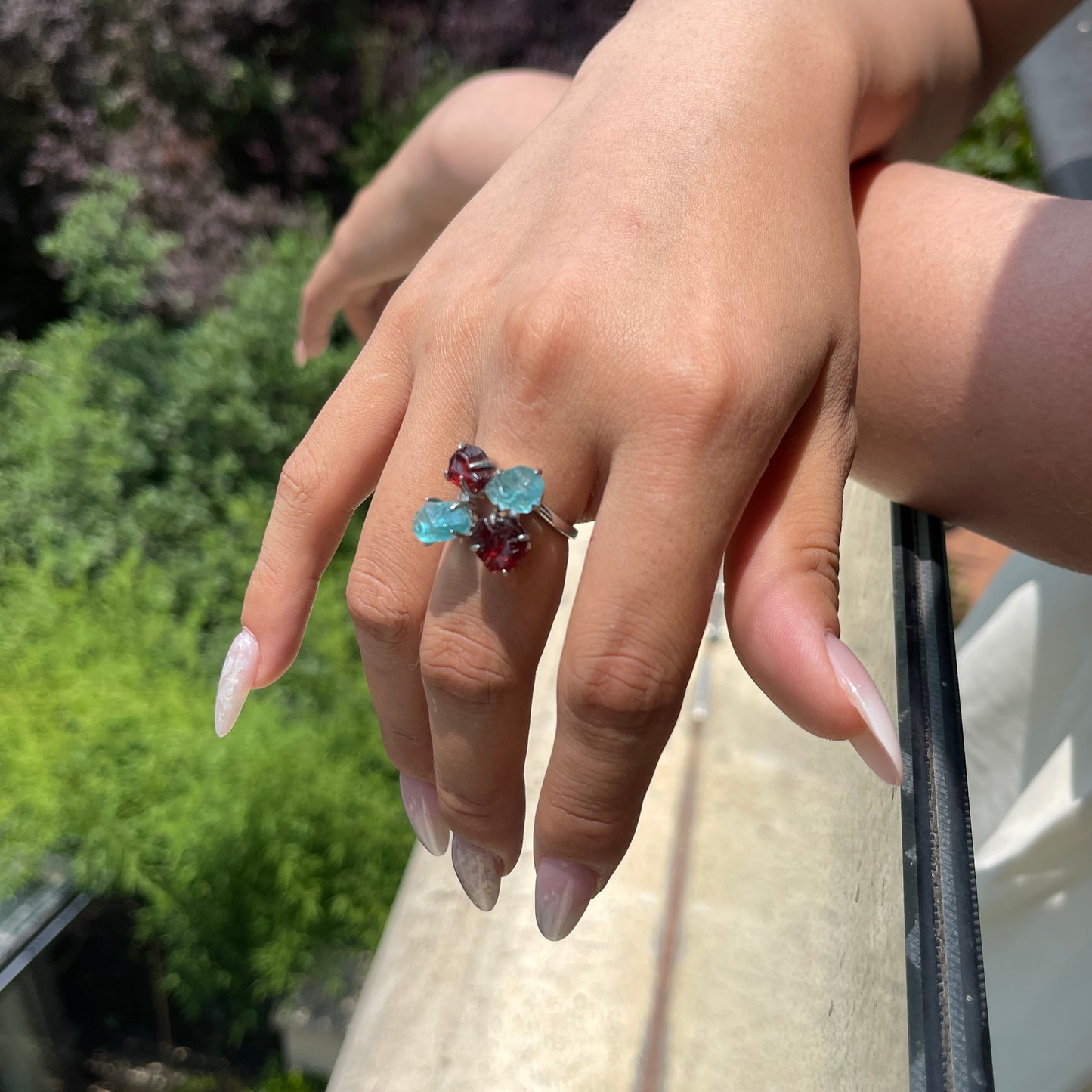 Close-up hand view of Raw Garnet and Blue Apatite crystal ring