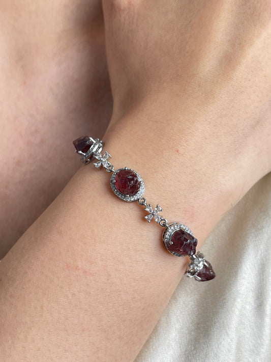 Close-up of raw garnet bracelet worn on wrist