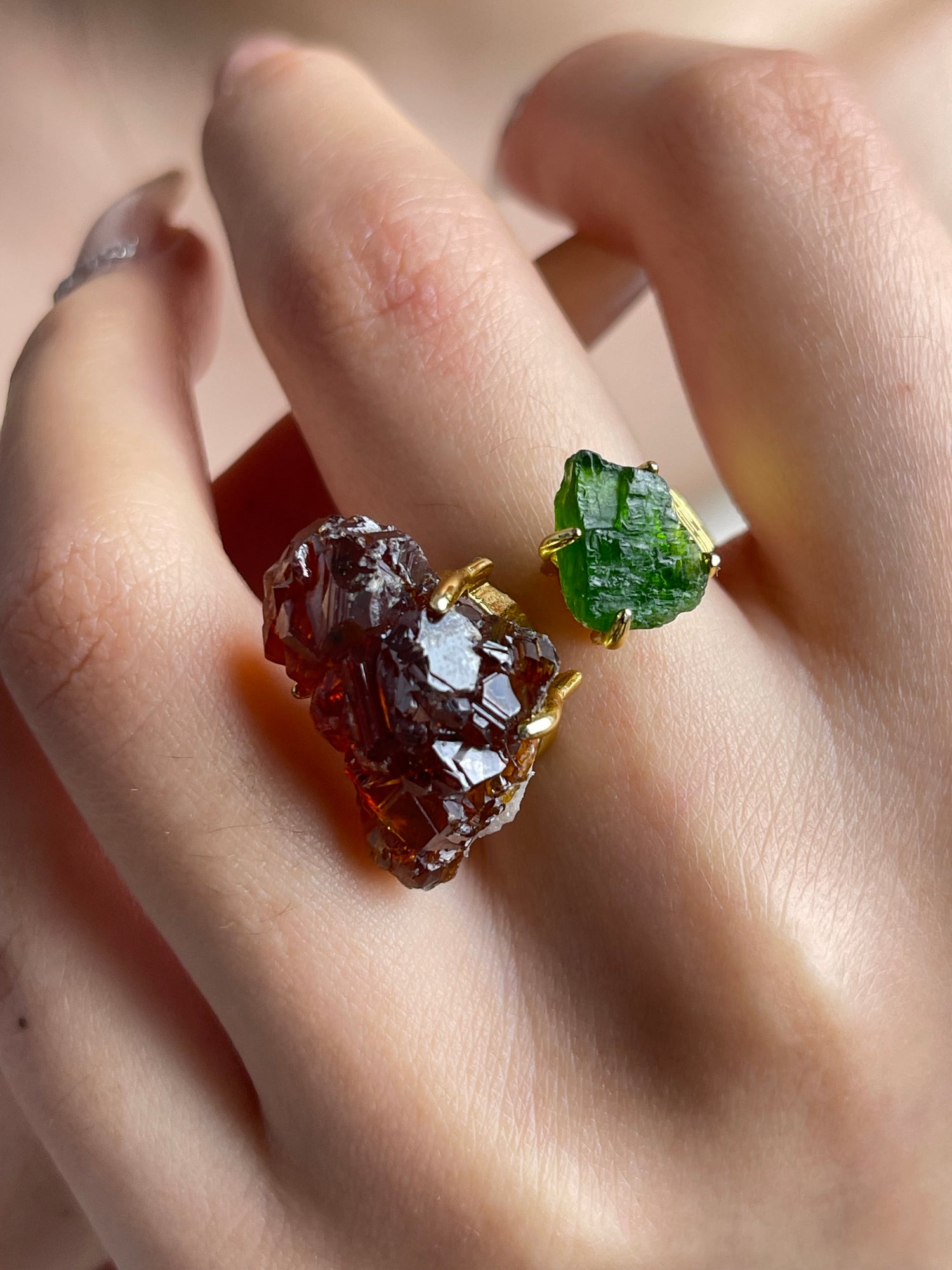 Close-up hand shot of raw garnet and chrome diopside ring