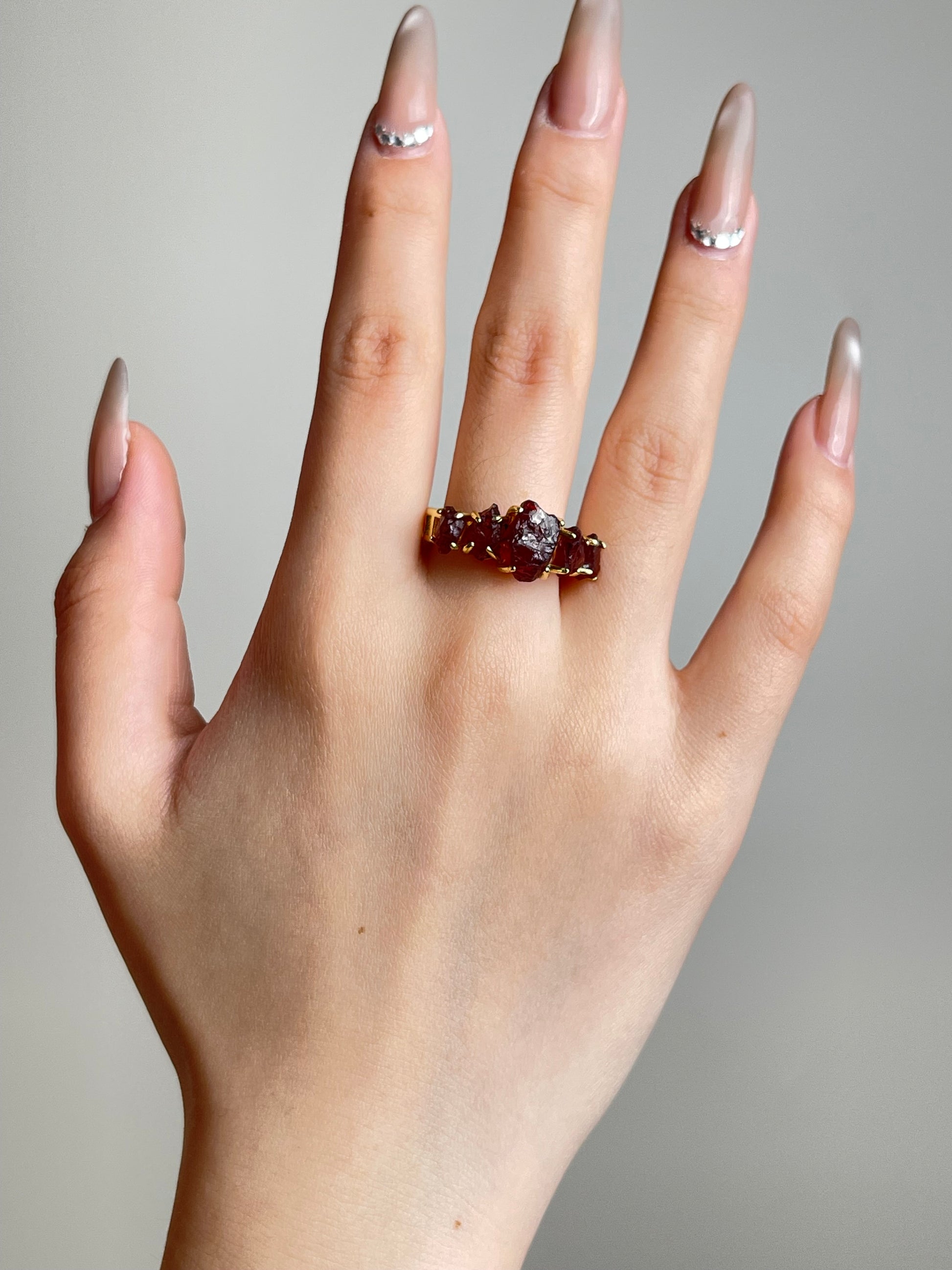 Raw garnet ring worn on hand
