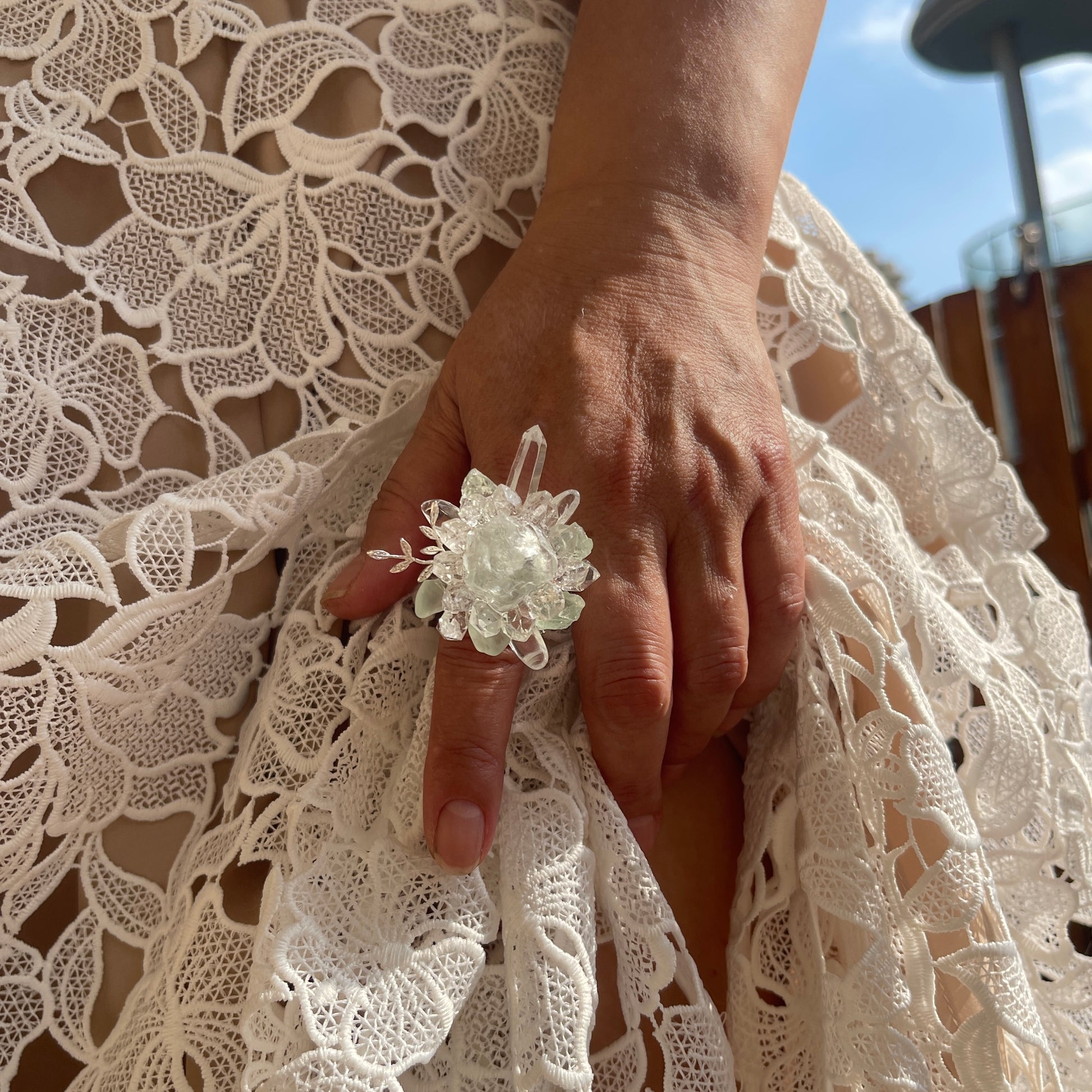 Close-up hand view of raw Green Fluorite and Herkimer Diamond Quartz crystal ring