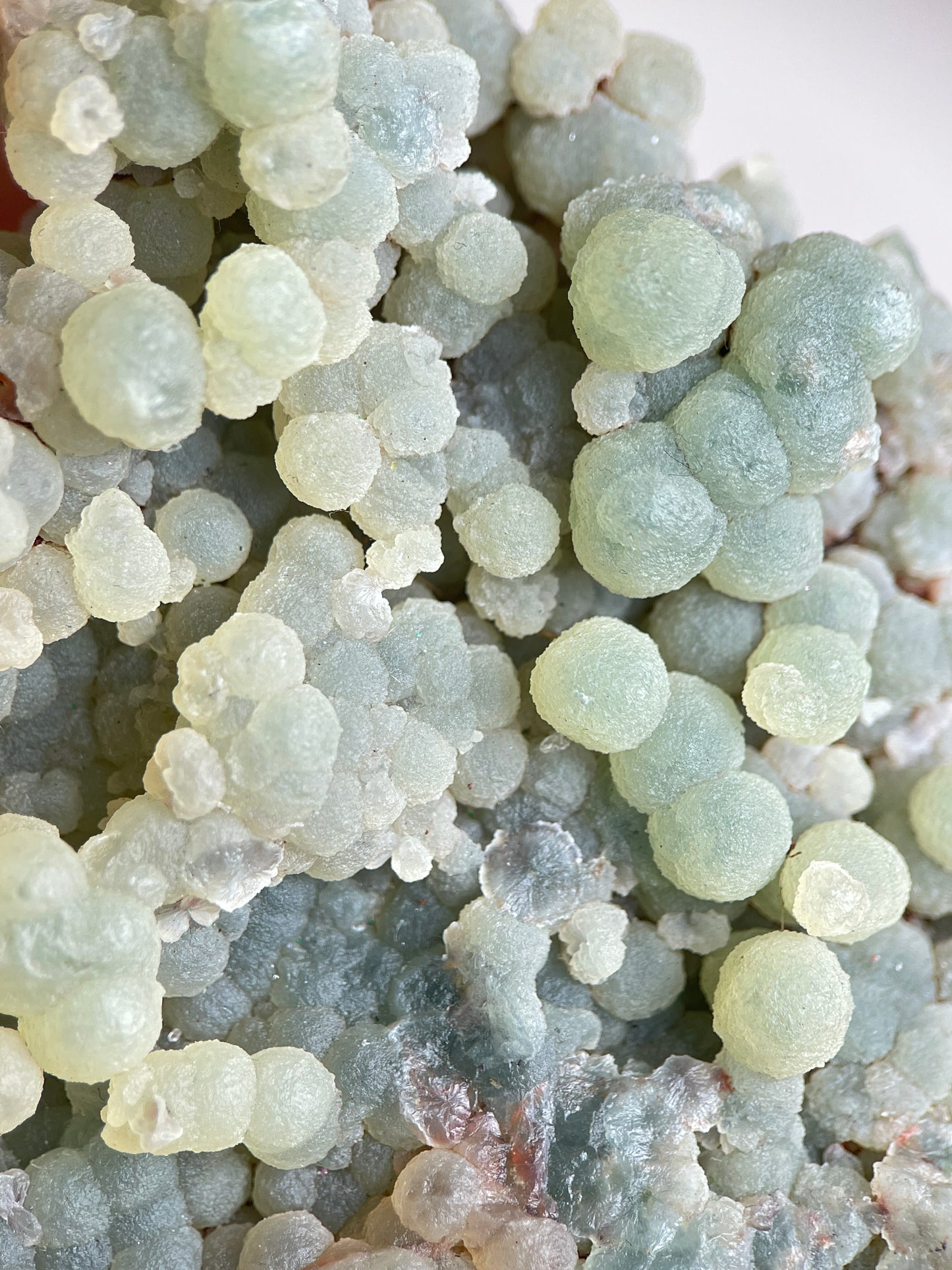 Detail of raw green prehnite cluster showing soft translucent green crystal texture