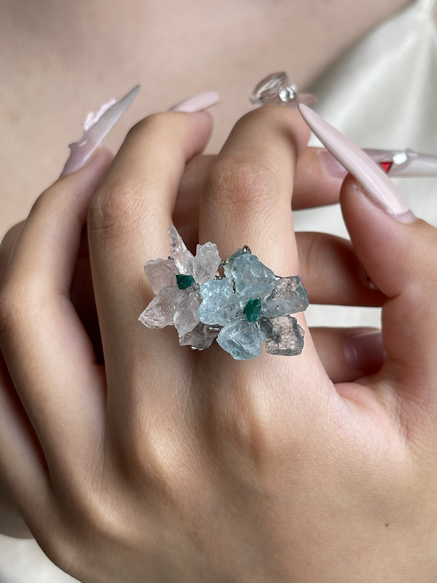 Raw Morganite and Aquamarine flower ring with Dioptase centers worn on hand