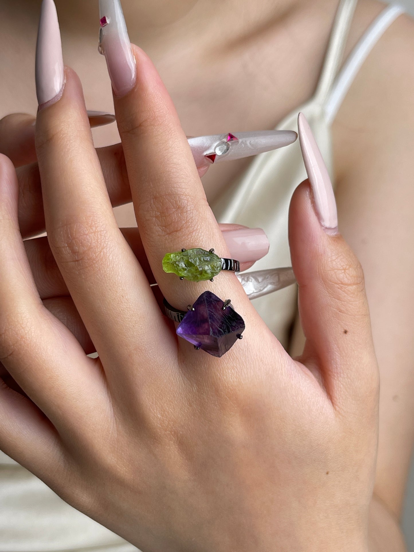 Raw peridot and purple octahedral fluorite ring worn on hand