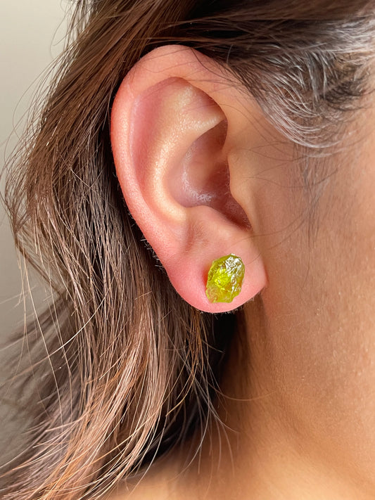 Raw Peridot Stud Earrings close-up worn on ear