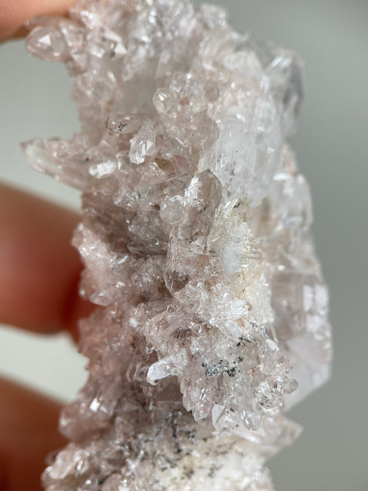 Detail of Pink Lemurian Quartz cluster showing manganese oxides and natural crystal texture