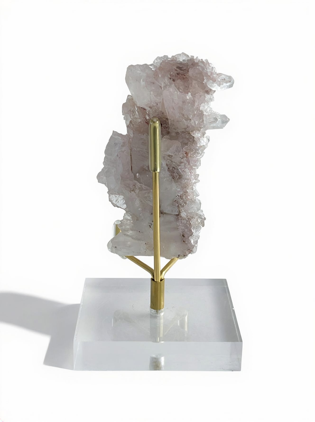 Back view of raw Pink Lemurian Quartz cluster with manganese oxides on display stand