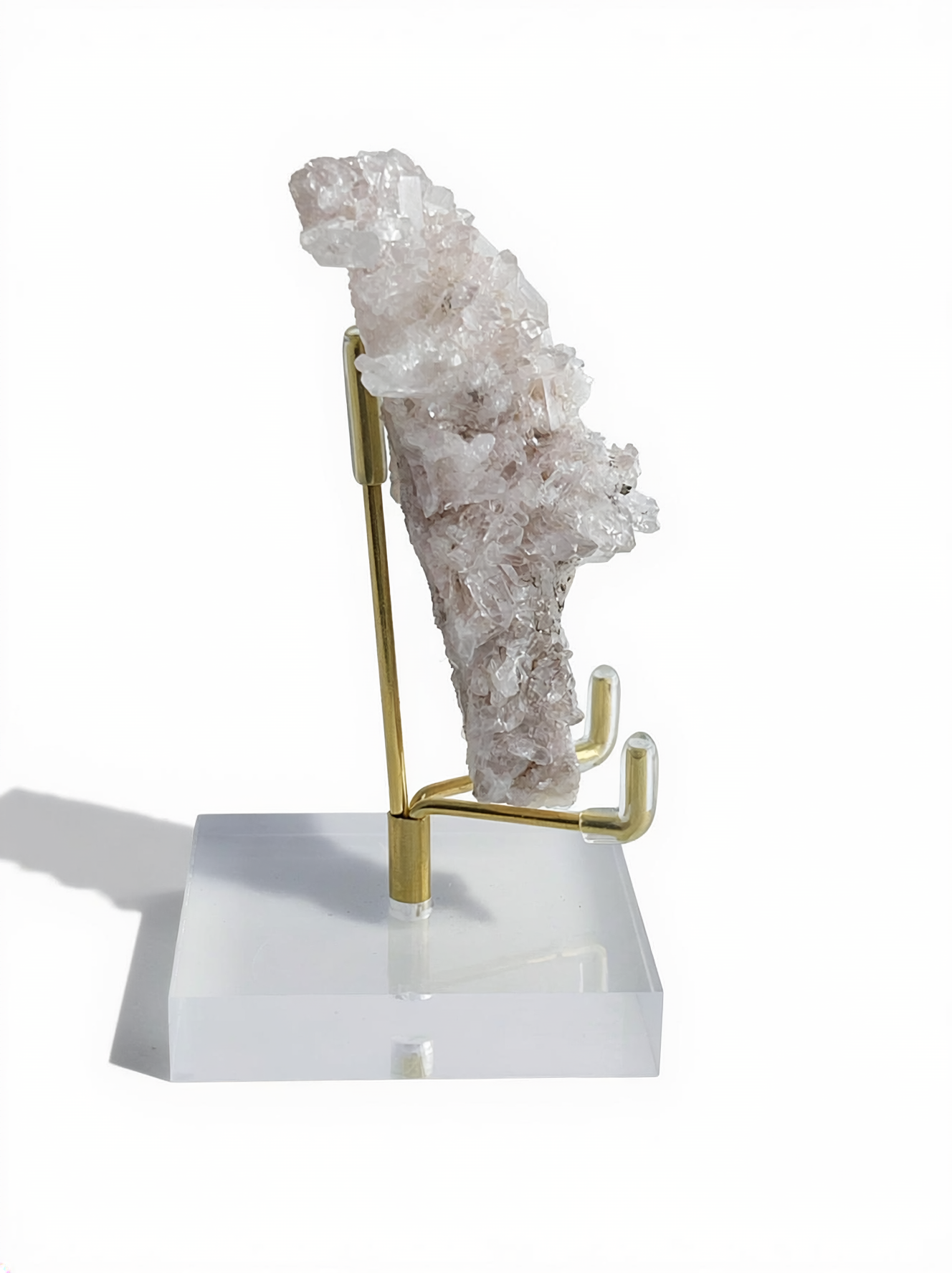 Raw Pink Lemurian Quartz cluster with manganese oxides on display stand, side view