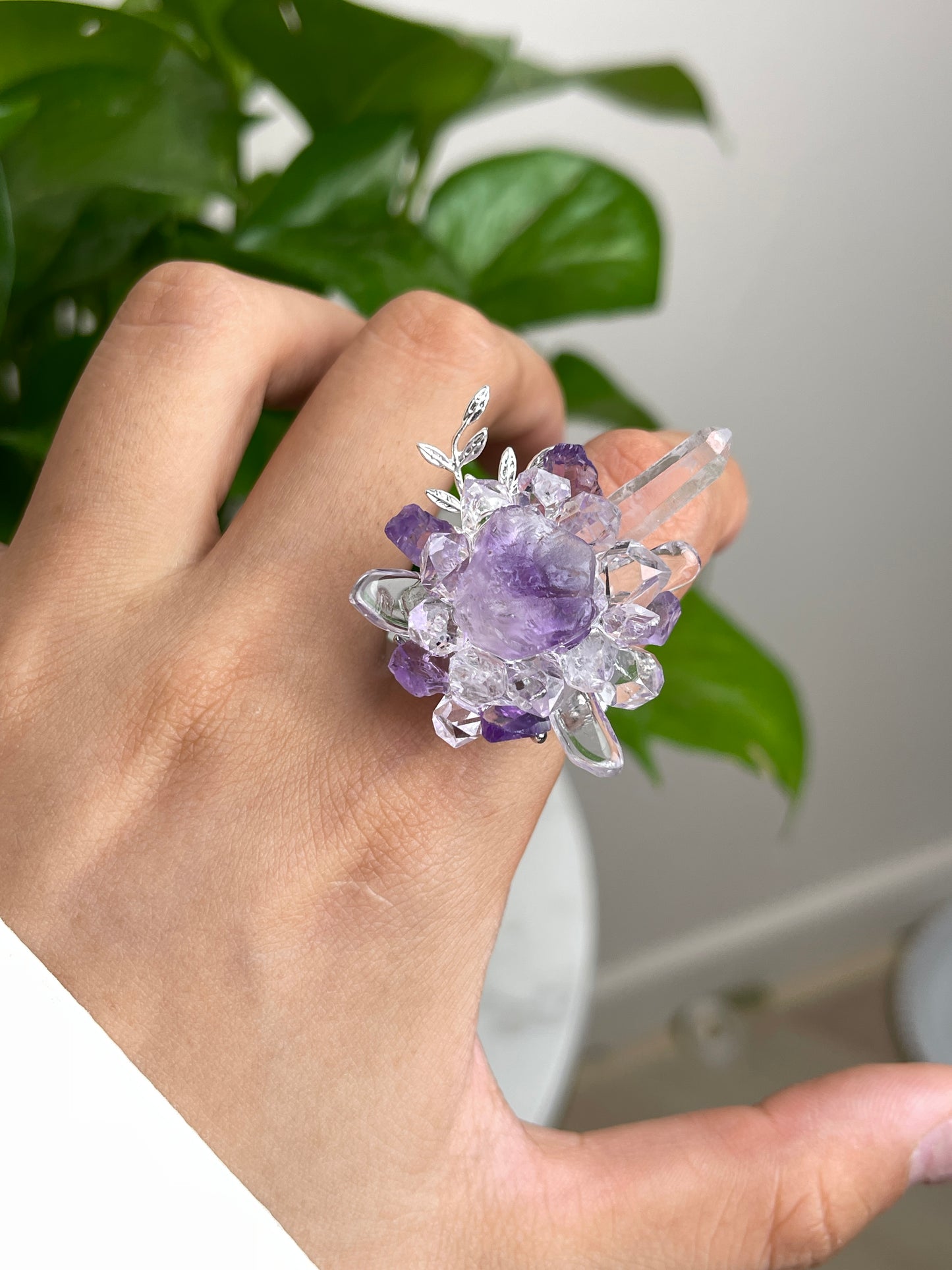 Close-up hand view of raw Purple Fluorite, Amethyst and Herkimer Diamond Quartz crystal ring