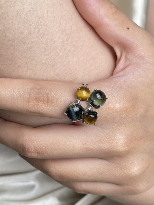 Close-up hand shot of tiger’s eye and blue tiger’s eye ring showing natural cat’s eye effect