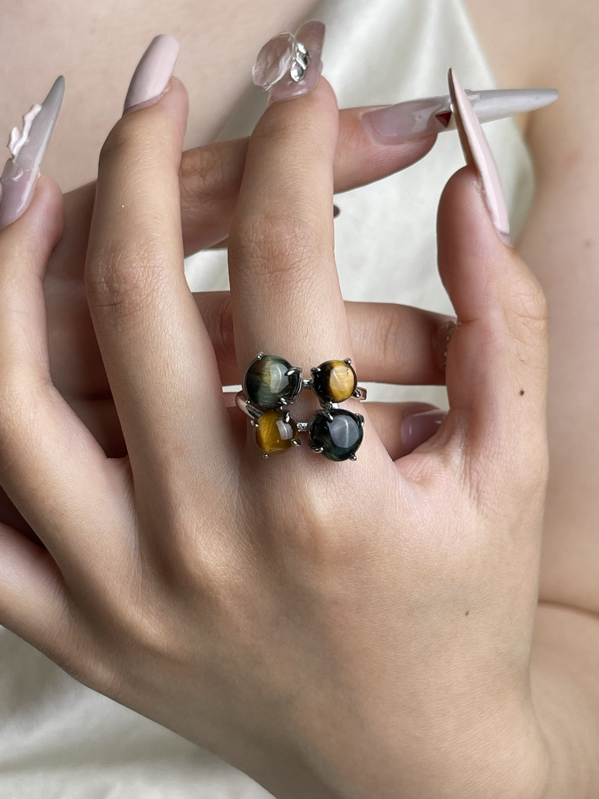 Tiger’s eye and blue tiger’s eye ring worn on hand with golden and blue chatoyant stones
