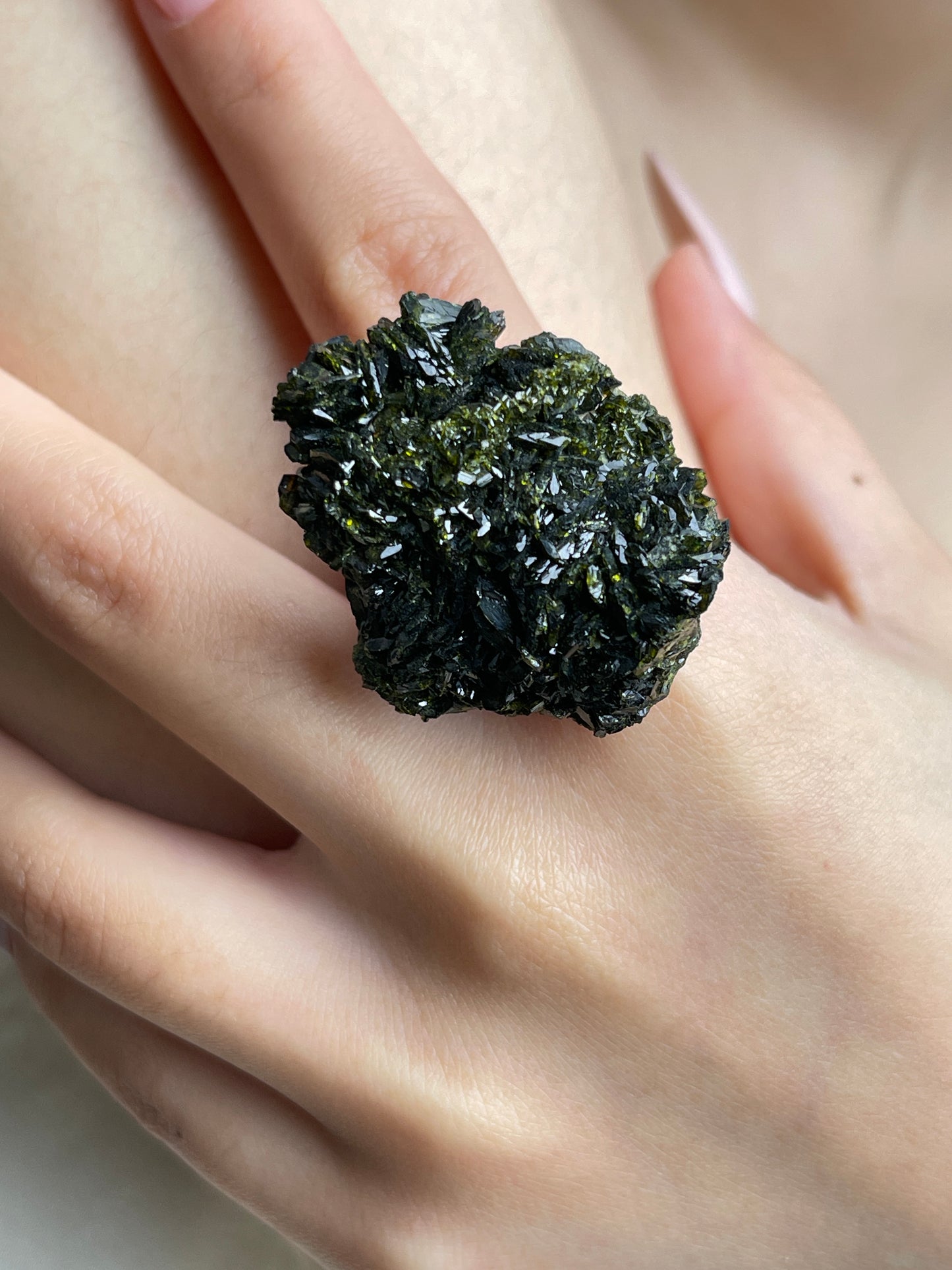 Close-up of Turkish epidote mineral specimen ring on hand