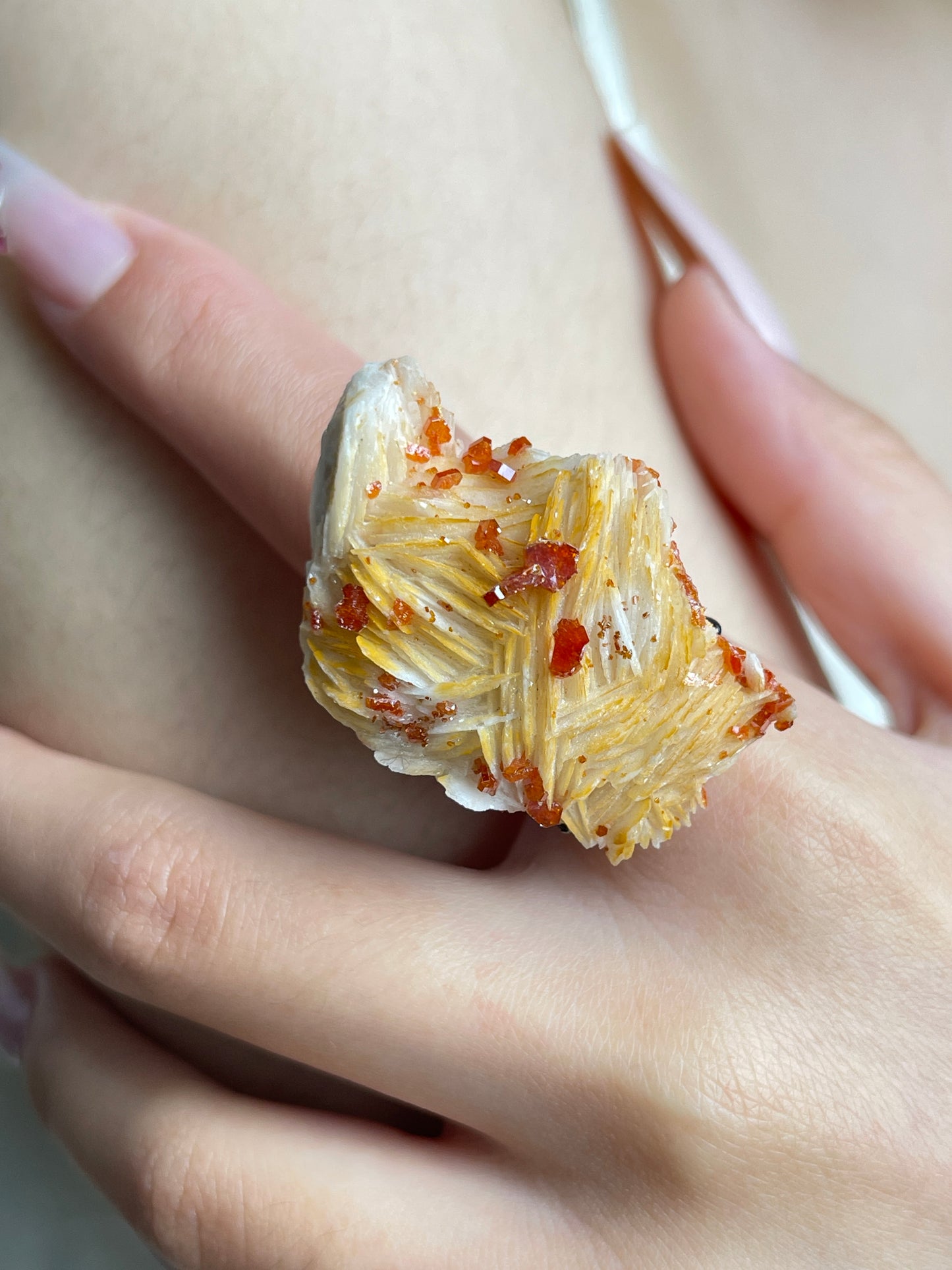 Close-up of Vanadinite on Barite mineral specimen ring worn on hand