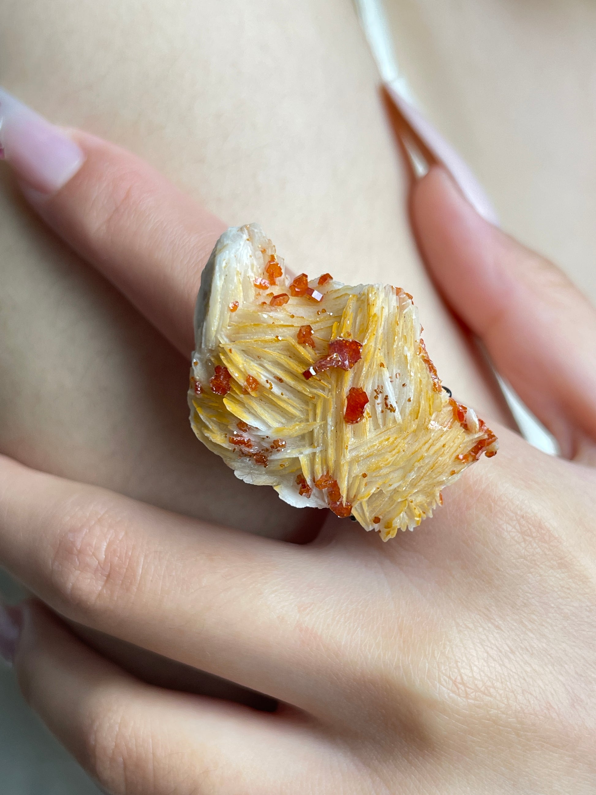 Close-up of Vanadinite on Barite mineral specimen ring worn on hand
