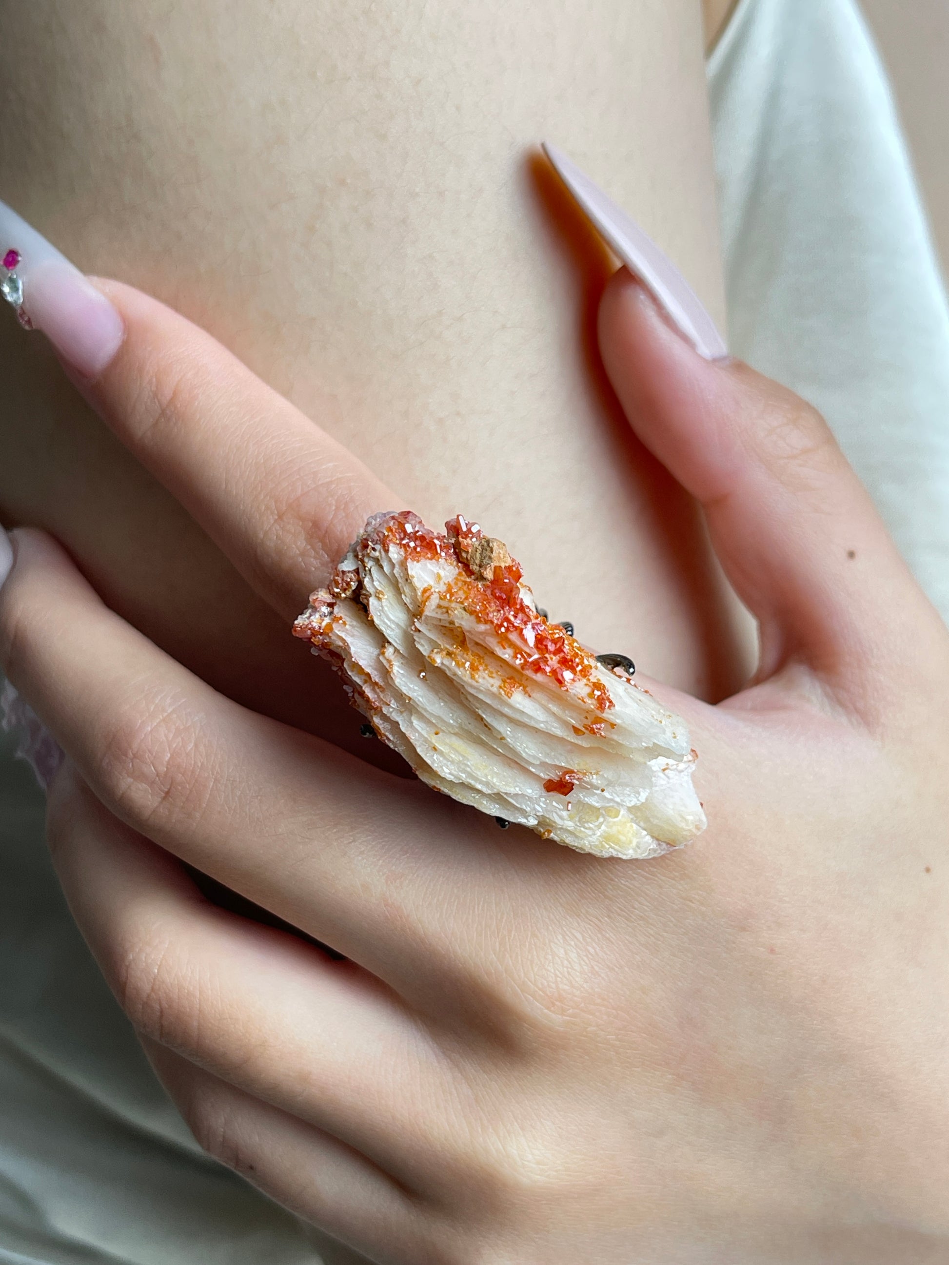 Close-up of Vanadinite on Barite mineral specimen ring worn on hand